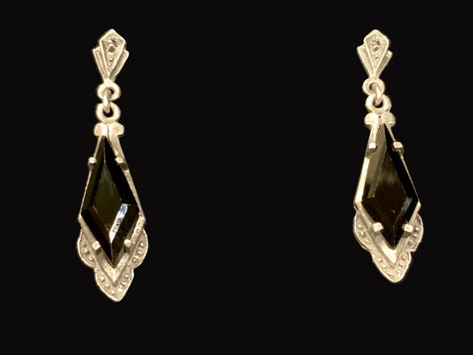 Pair of silver earrings with black gemstones on a black background