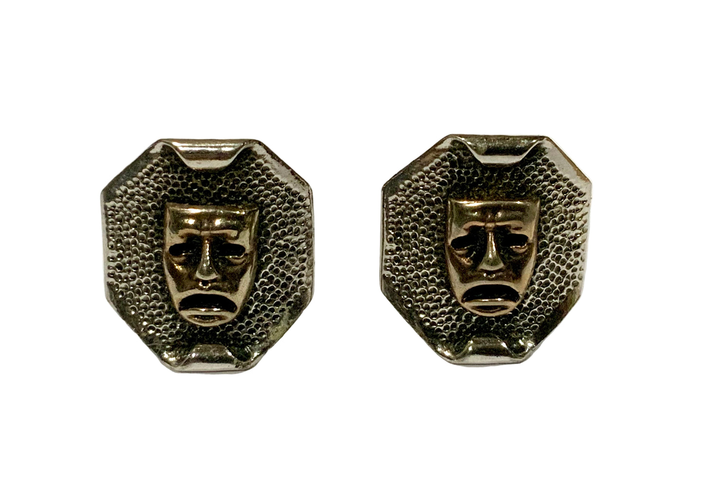 Pair of metallic face-shaped earrings on a white background