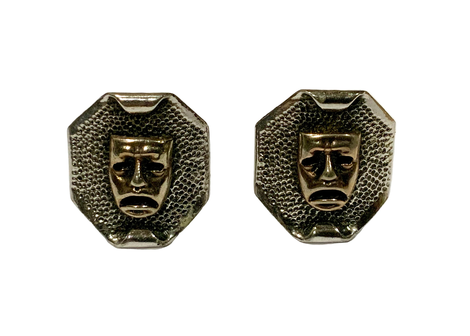Pair of metallic face-shaped earrings on a white background